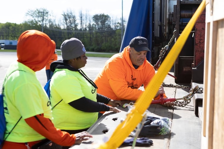 High school students learning how to strap down heavy machinery at career day.