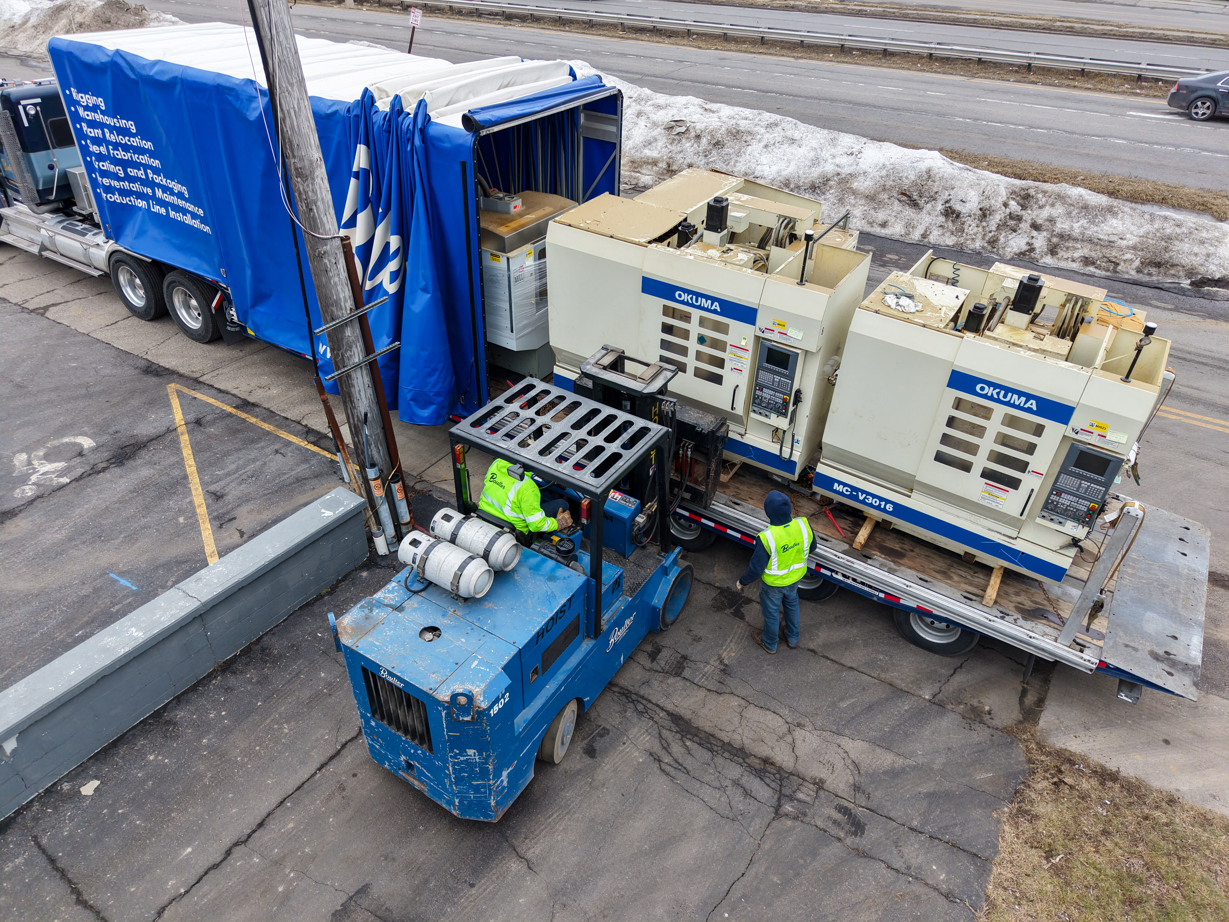 Field Technicians Offloading Multi Axis CNC Machine