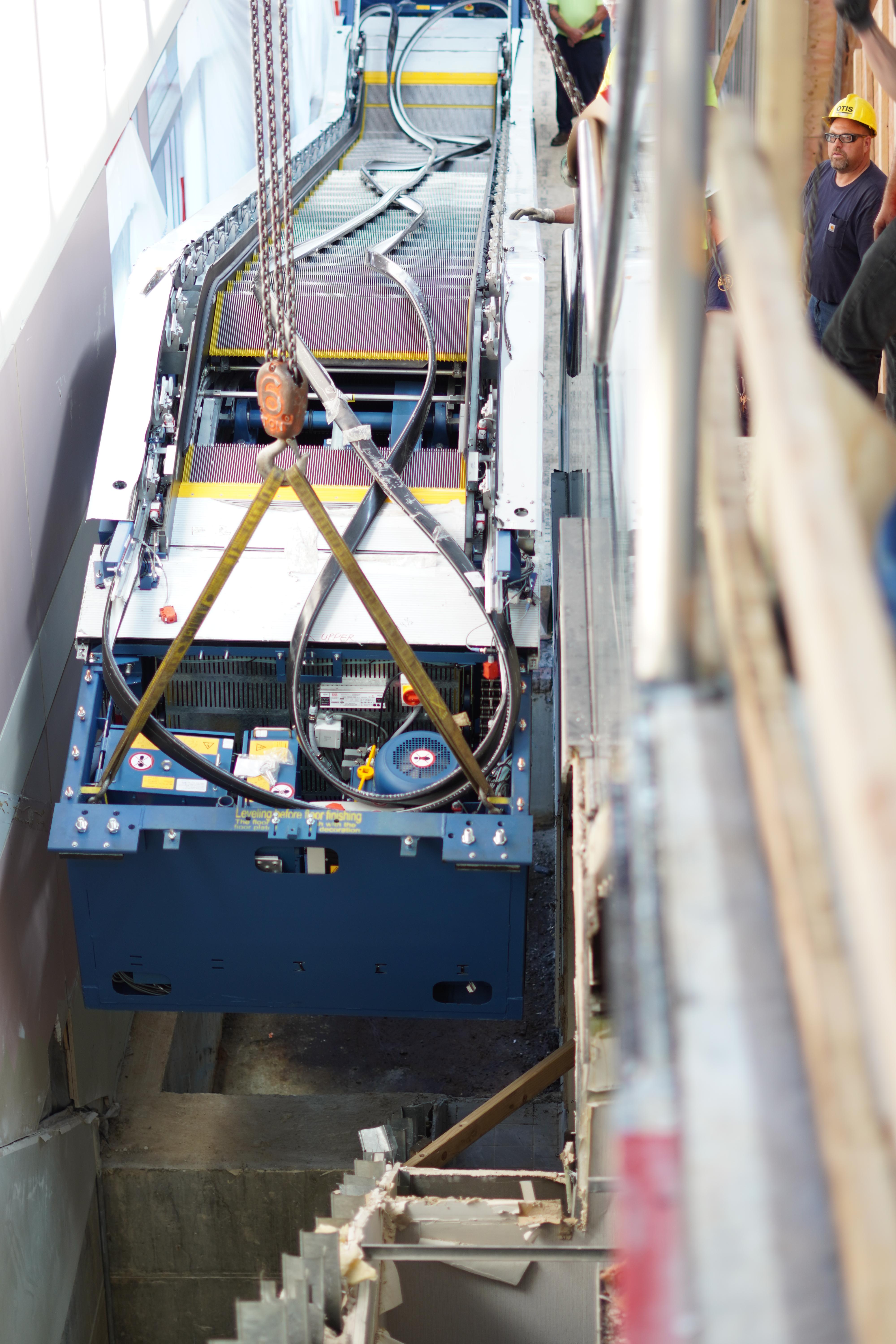 View of an escalator being lowered and removed out of position