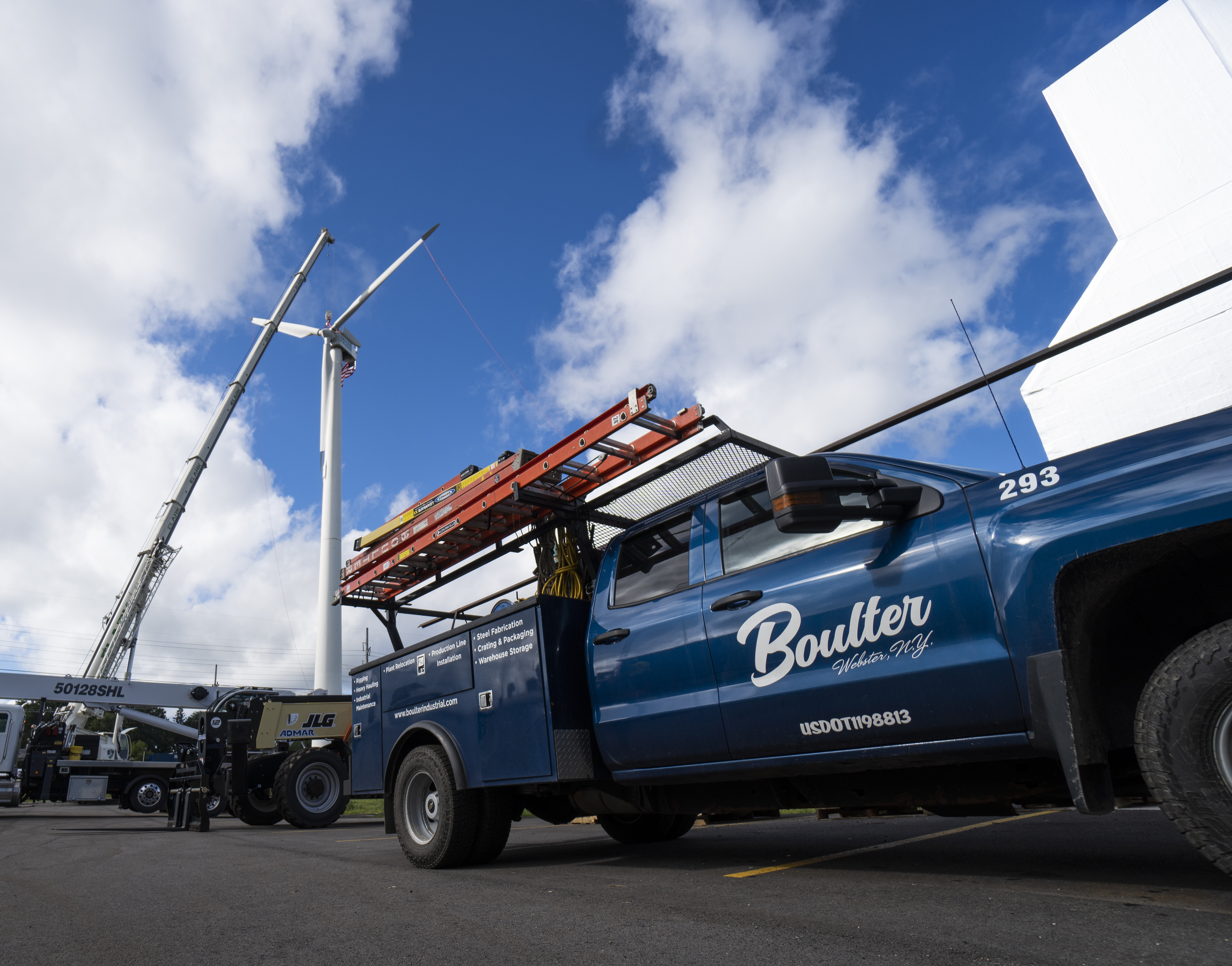 Welding service truck positioned next to hanging wind turbine blade