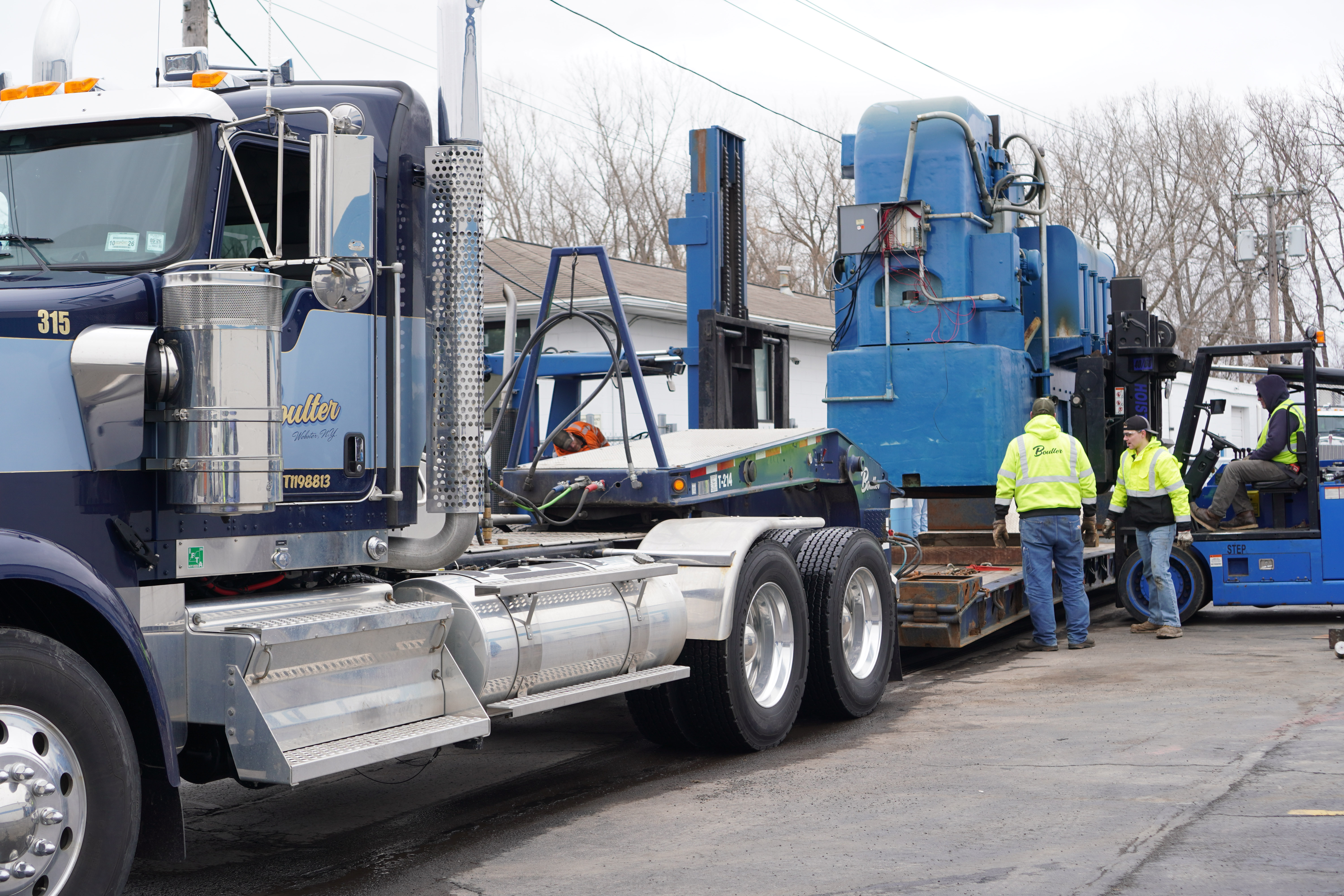 Boulter Truck Backing Trailer Under Hoisted Grinding Machine