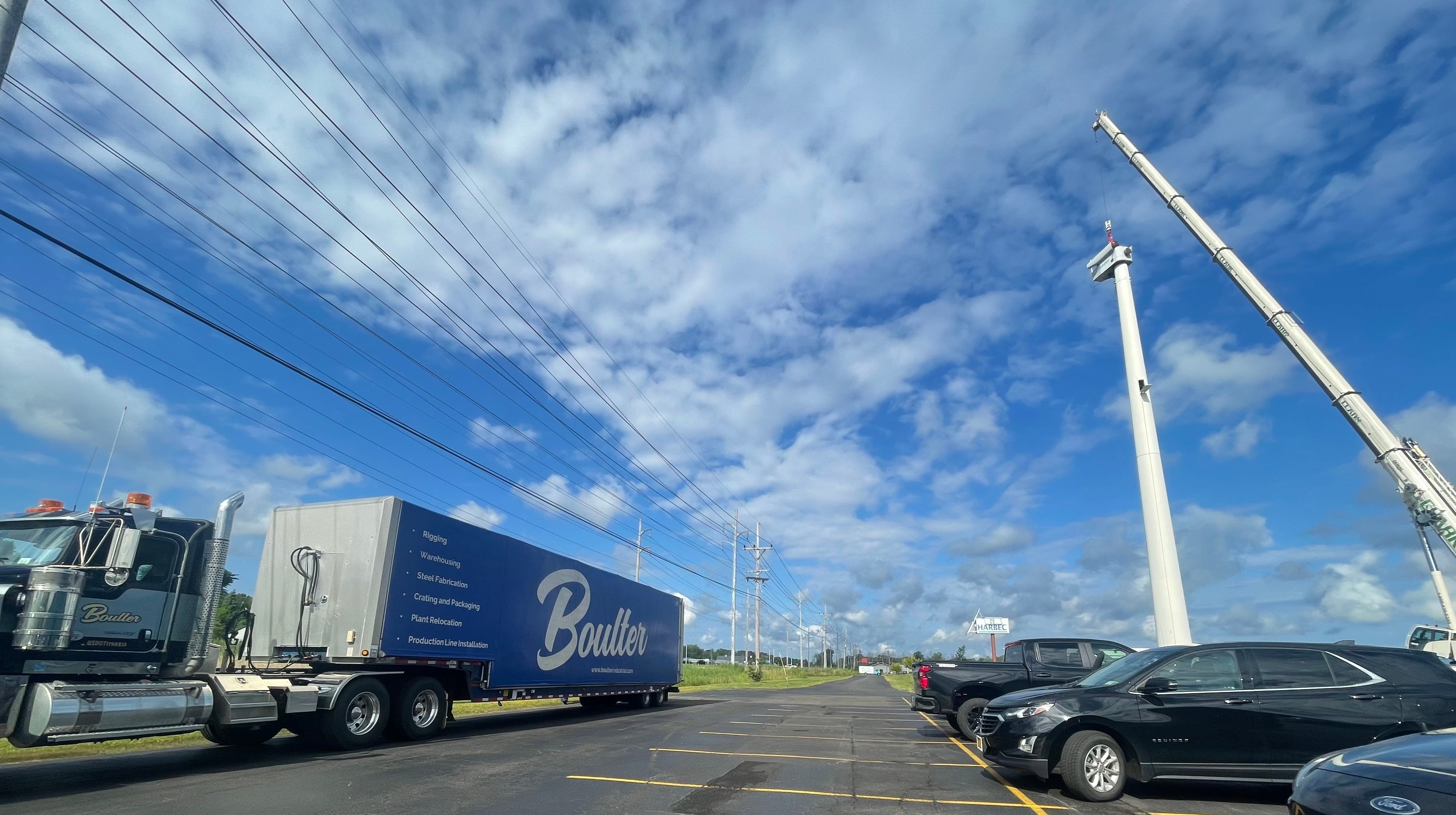 Boulter tractor trailer sitting next to Harbec wind turbine