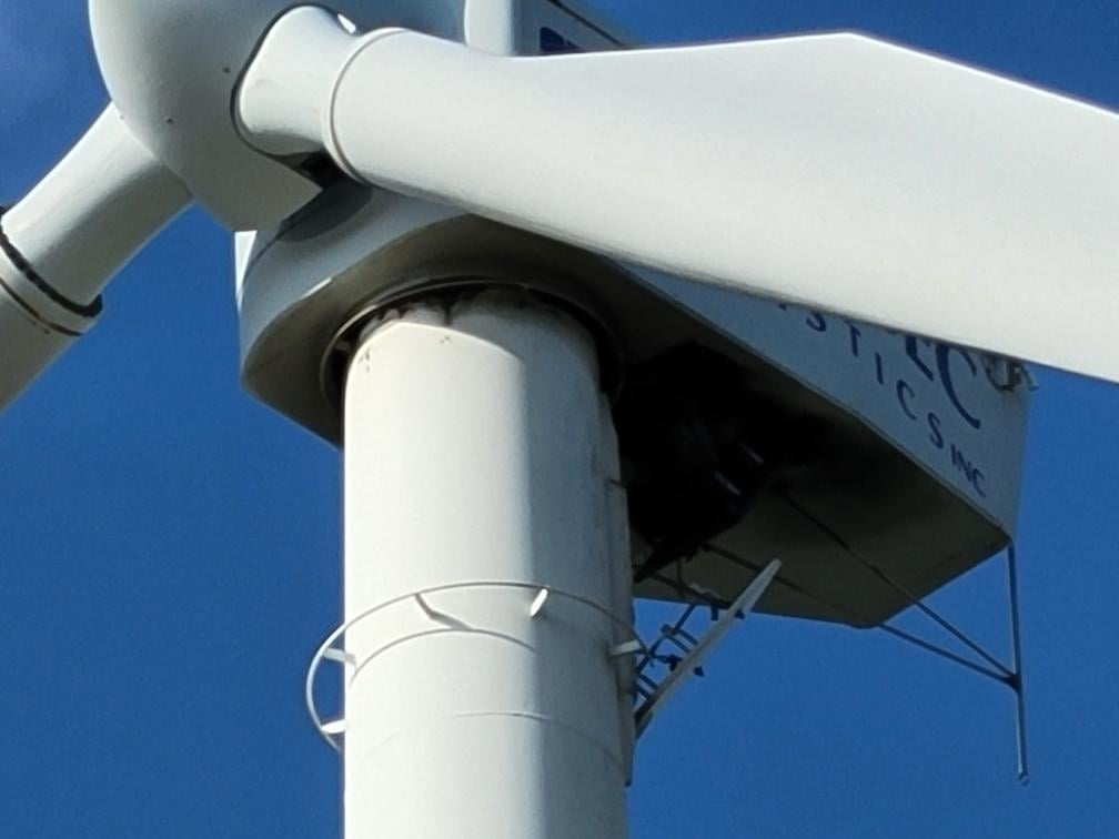 Group of people working within the wind turbine to remove bolts