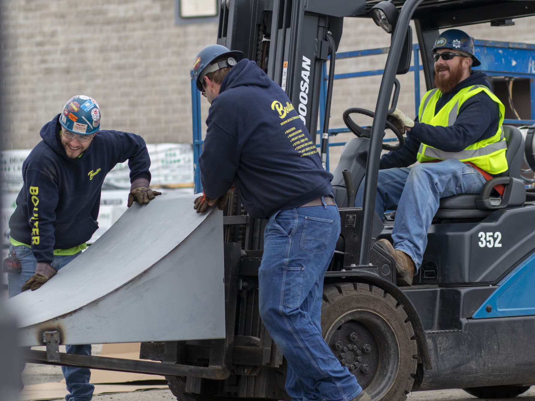 Happy field technicians moving equipment with forklift